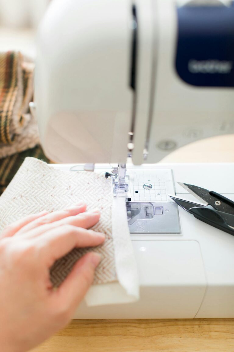 A close-up image showcasing a sewing machine actively stitching fabric with scissors nearby.