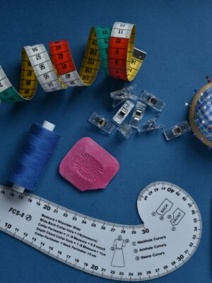 Sewing kit with colorful tools on a blue background, perfect for DIY and crafts.