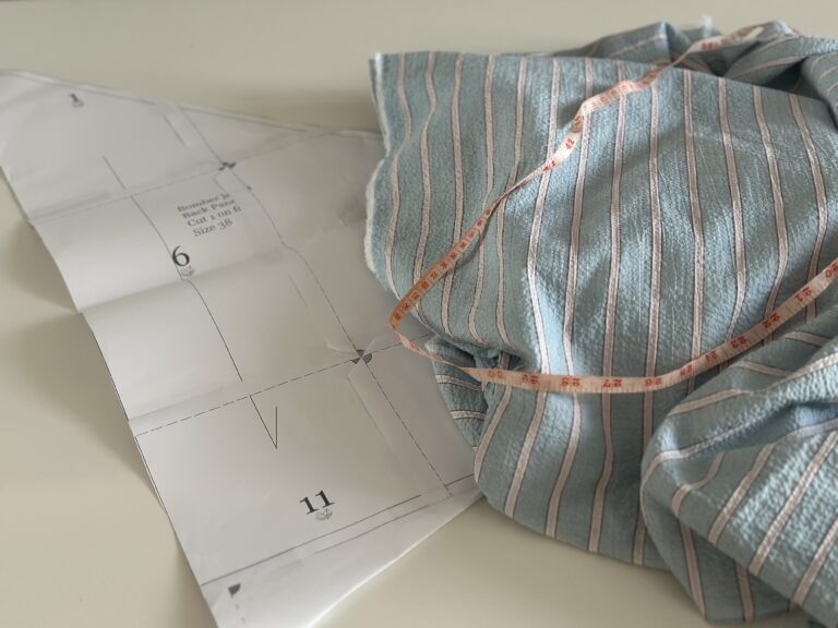 Printed pattern pages laid out and taped together on a table