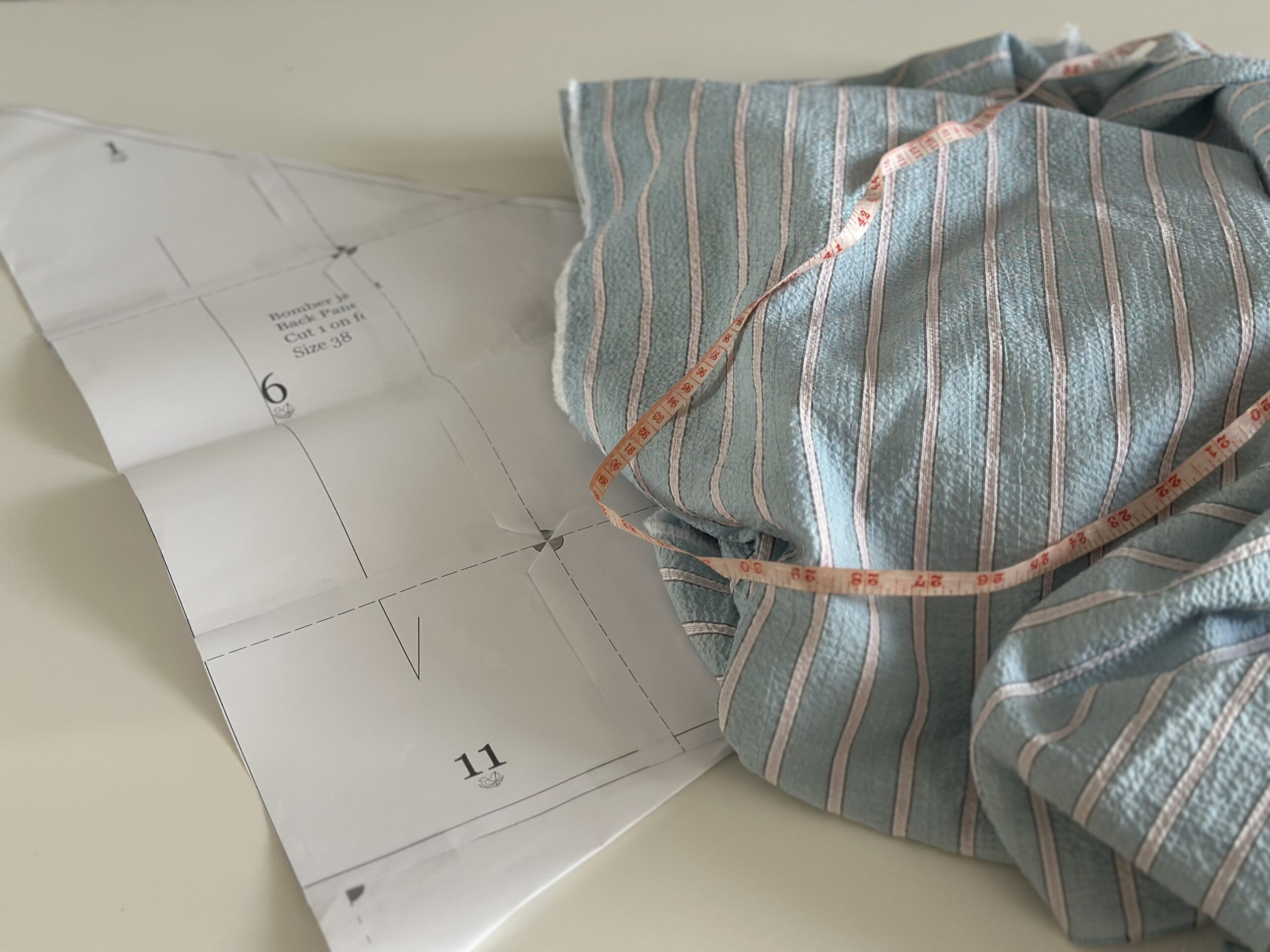 Printed PDF sewing pattern pages taped together on a table