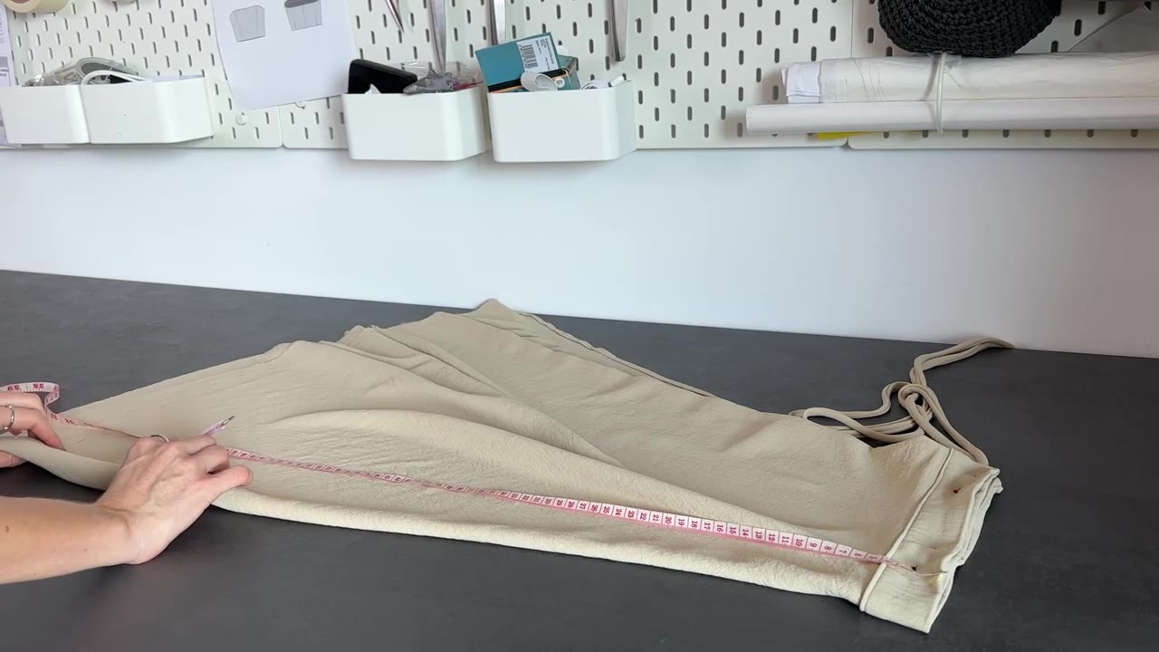 Pinning the paper pattern piece onto the fabric before cutting
