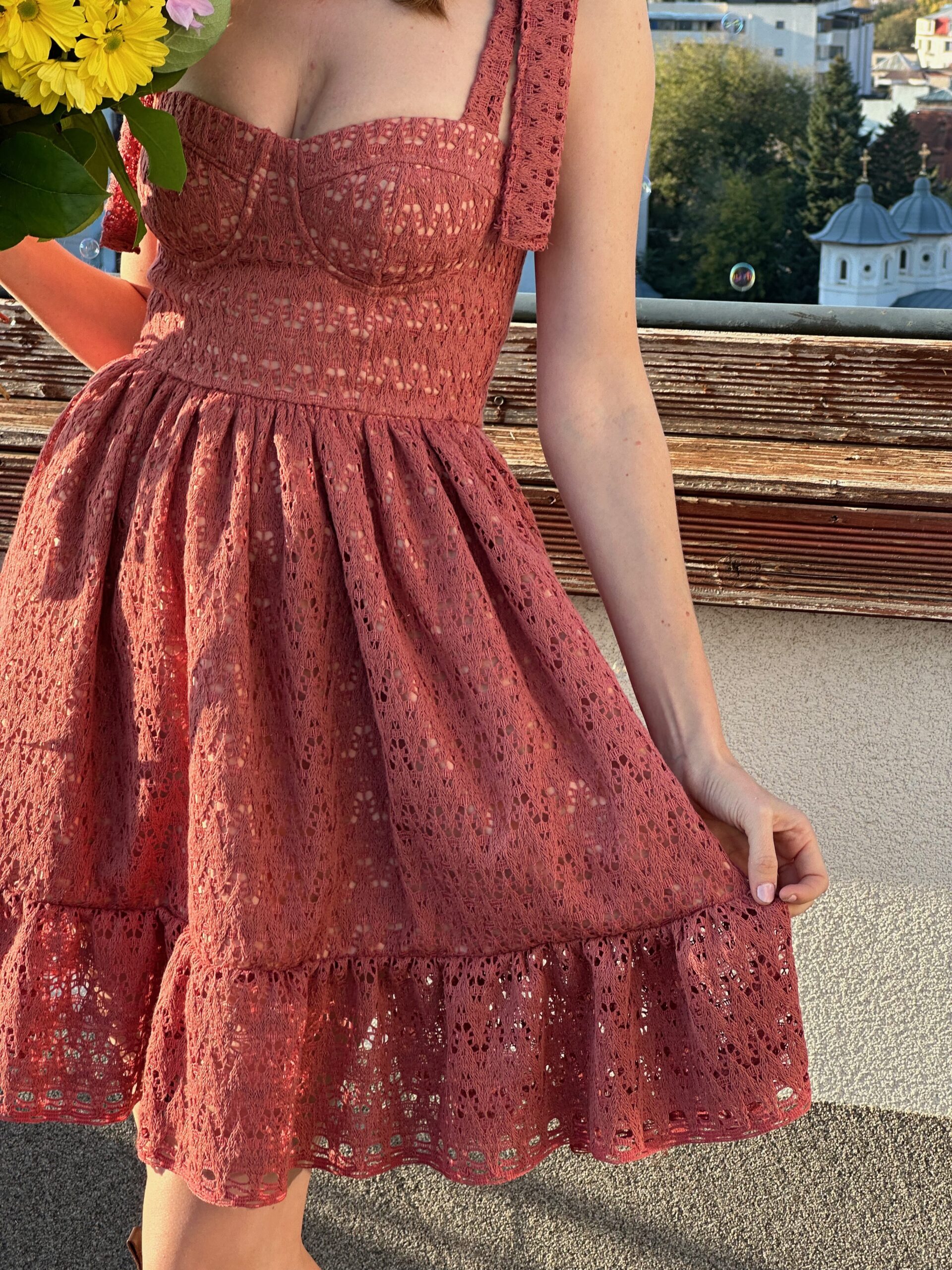 Close view of the bustier dress bodice, cup seams and gathered skirt in red floral print