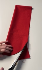 Cutting a curved shape at the folded corner to round the ends of the bow tails