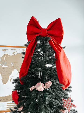 The oversized red fabric bow used as a Christmas tree topper