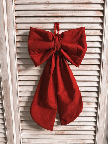 The fabric bow styled on a white wall panel as a wreath-style decoration