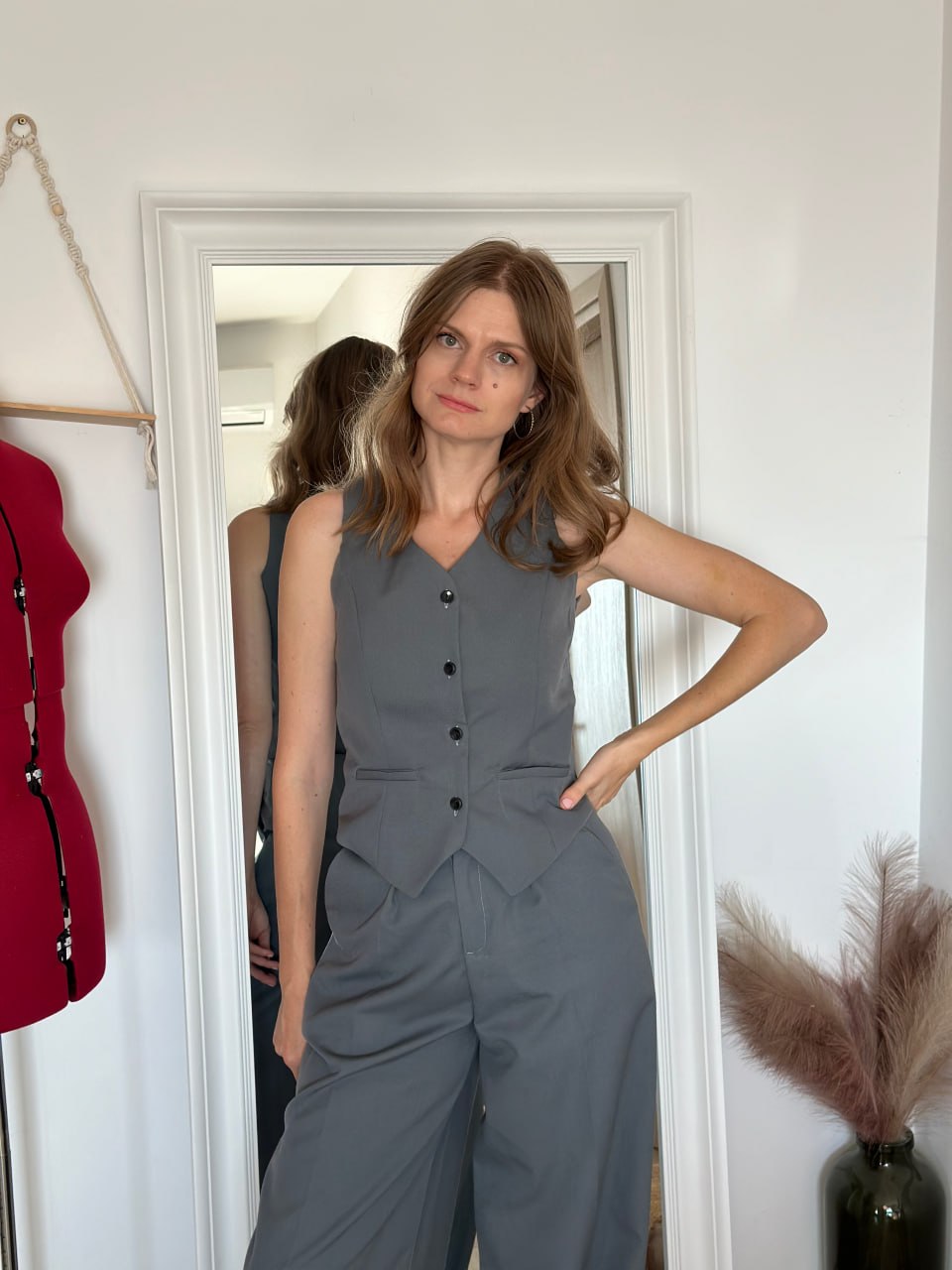 Side view of the waistcoat worn with wide-leg trousers, showing the drape